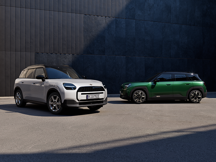Prikaz prednjeg kraja i bočnih strana potpuno električnog MINI Aceman modela u Nanuq White i British Racing Green boji s krovom u Black boji na ulici.