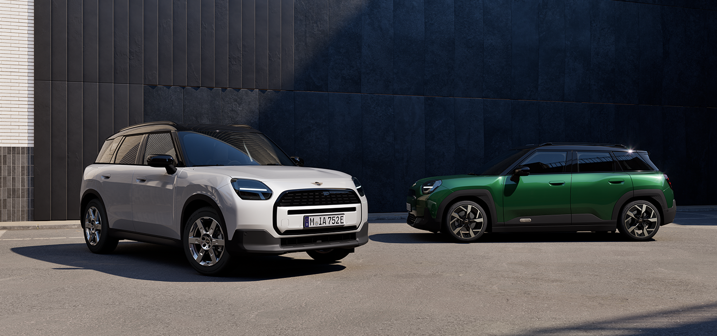 Prikaz prednjeg kraja i bočnih strana potpuno električnog MINI Aceman modela u Nanuq White i British Racing Green boji s krovom u Black boji na ulici.