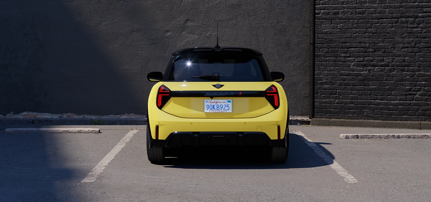 Prikaz stražnjeg kraja parkiranog MINI Cooper modela u Sunnyside Yellow boji s krovom Black boje.