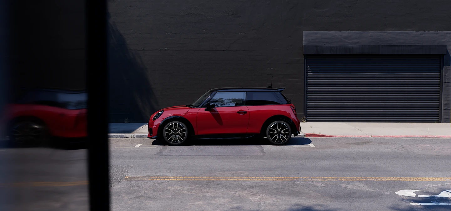 Bočni prikaz parkiranog MINI Cooper modela u Chili Red boji s krovom Black boje.