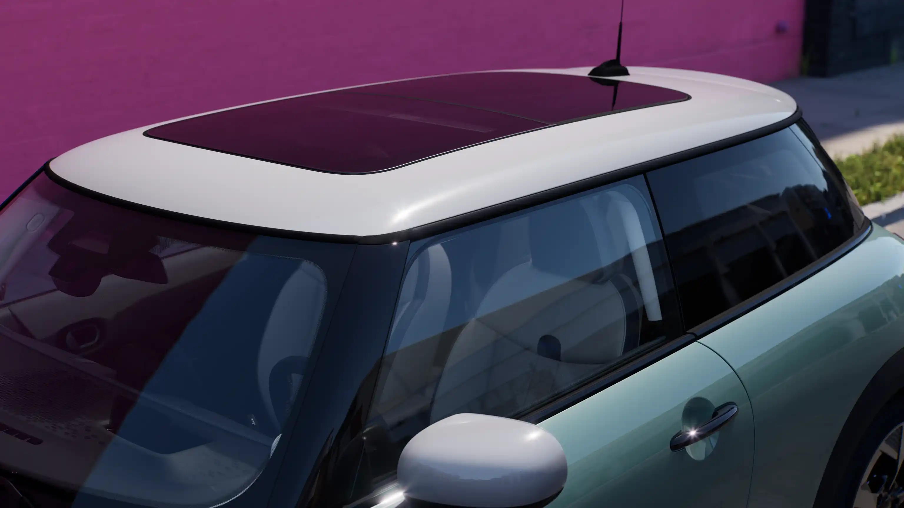 Prikaz MINI Cooper modela iz ptičje perspektive u Ocean Wave Green boji s kontrastnim krovom i velikim staklenim krovom.