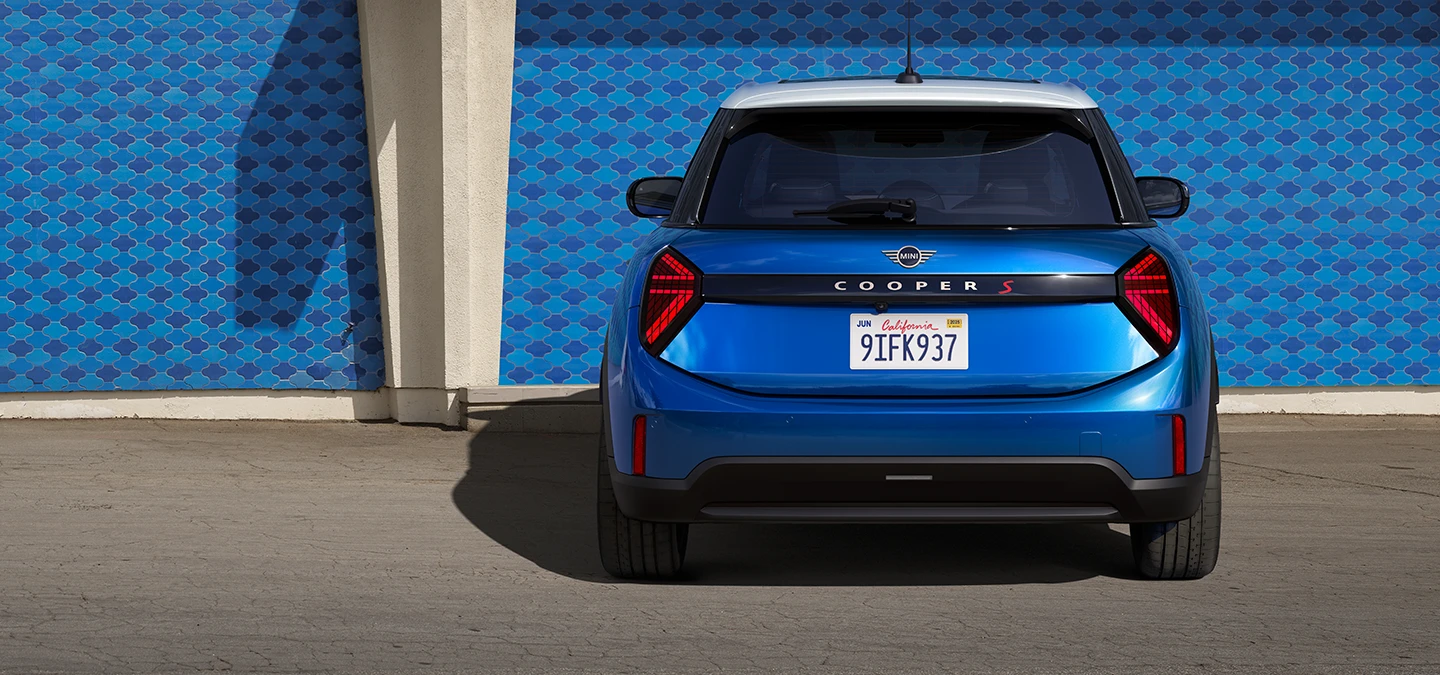 Prikaz stražnjeg kraja MINI Cooper modela s 5-vrata u Icy Sunshine Blue boji i krova u Multitone Roof Blue boji.