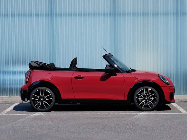 Bočni prikaz MINI Cooper Cabrio modela u Chili Red boji na ulici.