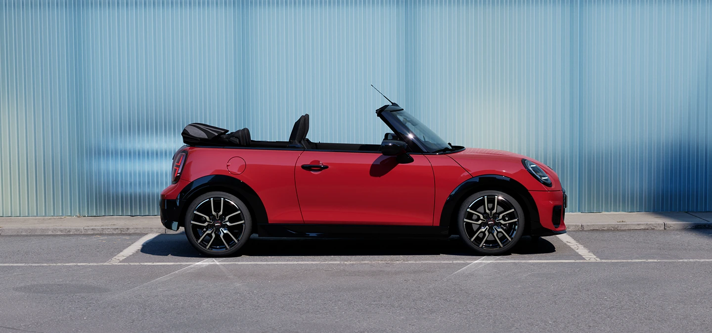 Bočni prikaz MINI Cooper Cabrio modela u Chili Red boji na ulici.