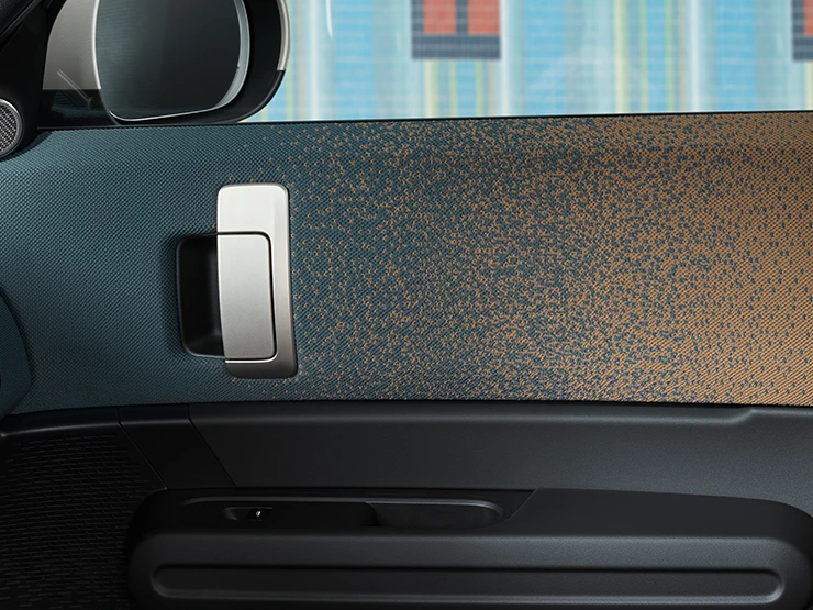 Detaljan prikaz dizajna unutrašnjosti potpuno električnog MINI Countryman modela s fokusom na vrata i nadzornu ploču.