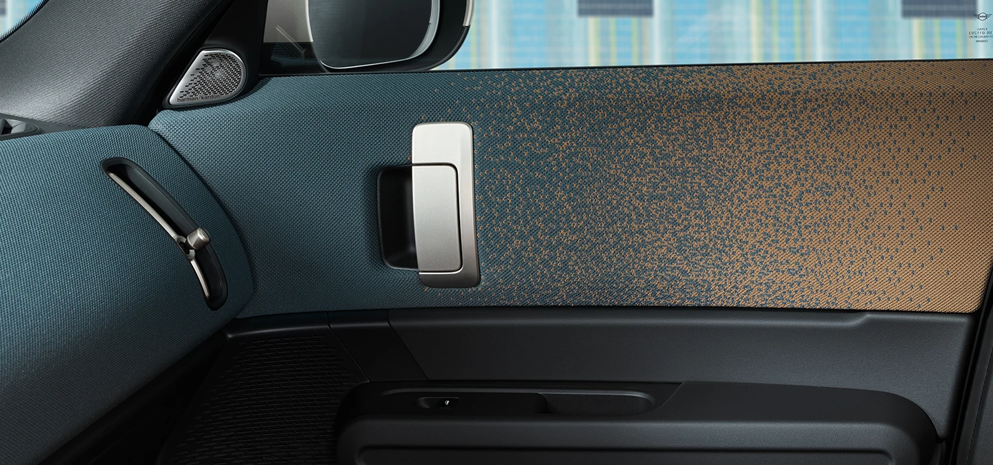 Detaljan prikaz dizajna unutrašnjosti potpuno električnog MINI Countryman modela s fokusom na vrata i nadzornu ploču.