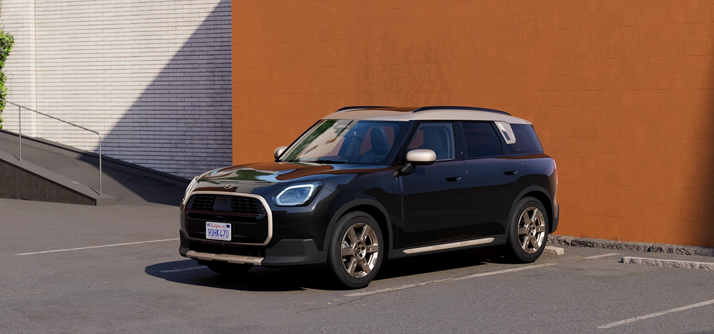 Prikaz prednjeg kraja MINI Countryman modela u Midnight Black boji i krovu Vibrant Silver boje na parkingu.