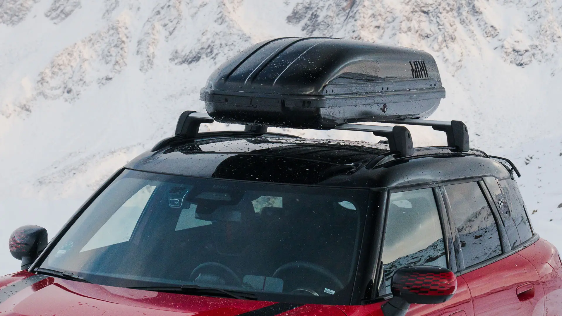 MINI Countryman u Chili Red II boji s MINI krovnom kutijom 320 u Black boji.