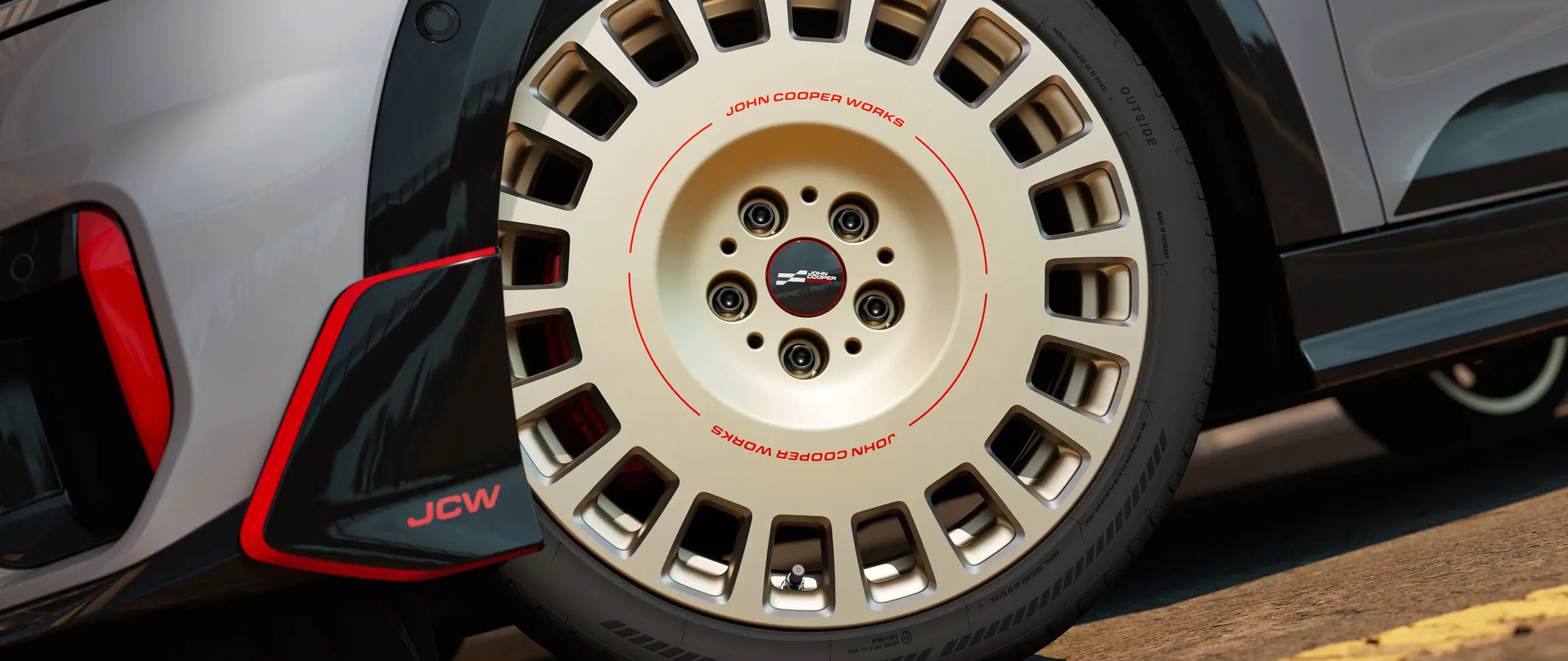 Prikaz detalja na 18-inčnom kotaču JCW Rallye Spoke 964 u Bicolour Vibrant Silver boji, obrade dijamantnim alatom i prednjem krilu.