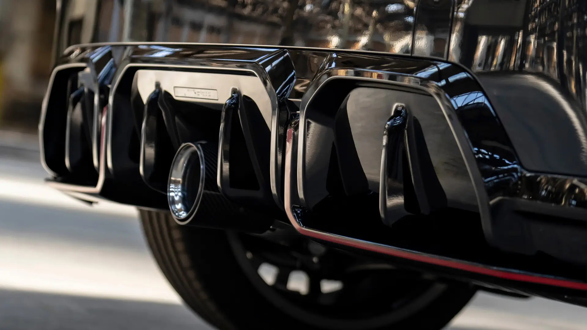 MINI John Cooper Works stražnji difuzor u crnoj boji visokog sjaja s crvenim okvirom.