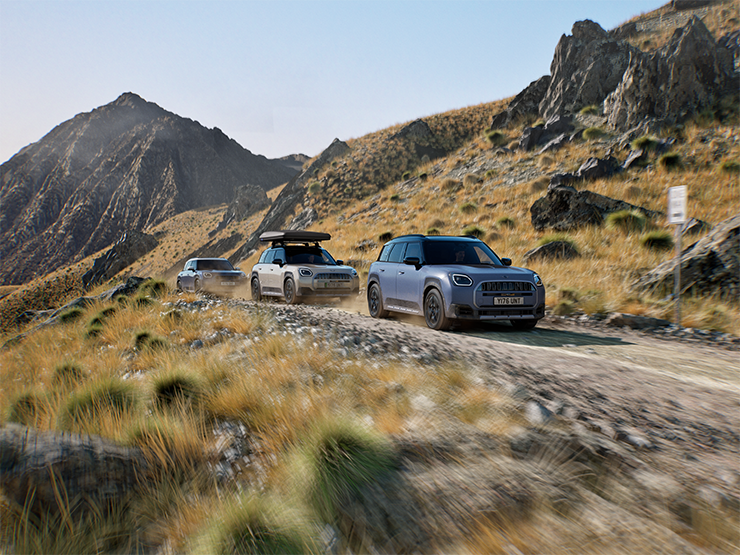 Prikaz više MINI Countryman Untamed Edition modela koji se voze terenom na planinskoj cesti.