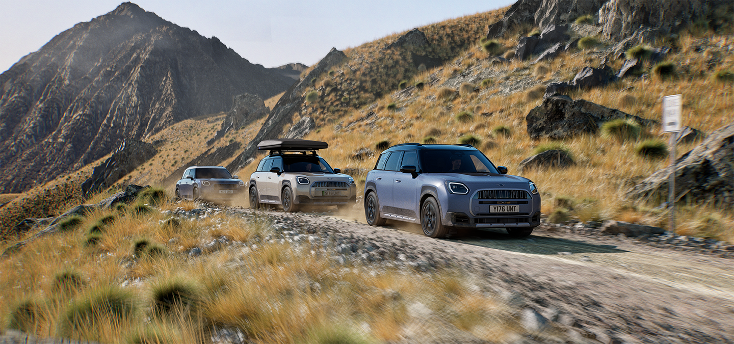 Prikaz više MINI Countryman Untamed Edition modela koji se voze terenom na planinskoj cesti.